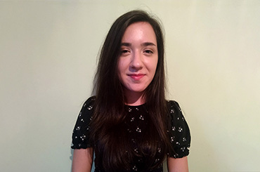 Picture of a girl (Telerik Academy alumni) in front of a wall in a bright colour