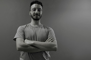 a black and white photo of bogomil, a telerik academy alpha javascript graduate in front of a grey wall